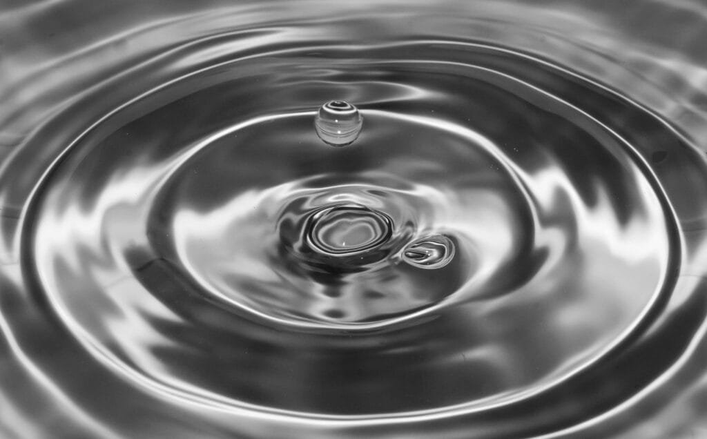 A captivating black and white macro shot capturing water drop ripples in a perfect splash.